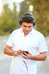 Young man chooses music on the phone for morning run.