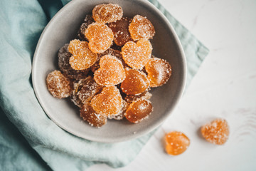 Homemade orange jelly beans heart shaped in the plate. View from above
