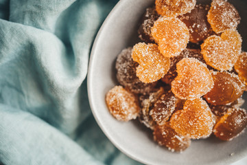 Homemade orange jelly beans heart shaped in the plate. View from above
