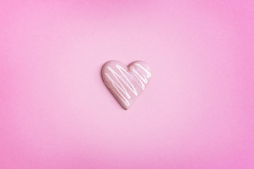 Pink chocolate in shape of heart on pink background. Holiday background with copy space for Valentines Day. Love concept.