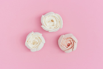 Flowers from marshmallow, sweet food background with copy space. Greeting card pastel colored. Top view and flat lay.