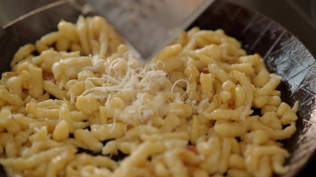 Close Up Grating cheese on top of Talharim