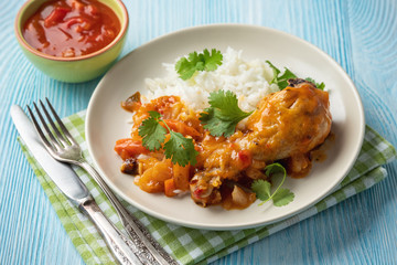 Chicken drumstick in tomato sauce with boiled rice.