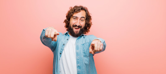 young bearded crazy man feeling happy and confident, pointing to camera with both hands and...