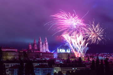 Distant colourful firework next to Santiago de Compostela Cathedral towers in purple evening sly