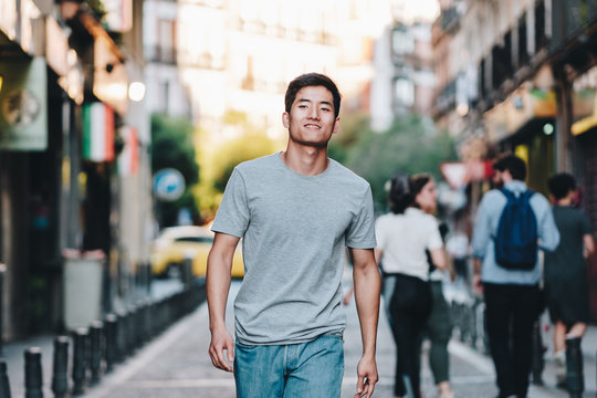 Content Modern Young Ethnic Man In T Shirt Strolling Along Urban Summer Street