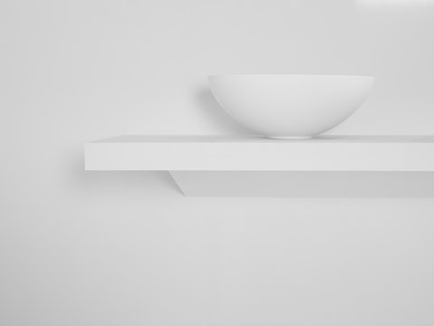 Ceramic bowl placed on simple shelf against white wall in bathroom