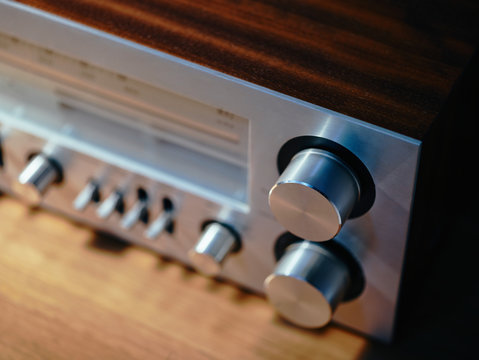 From above closeup of front of massive metallic retro turntable with built-in radio having radio dial with frequencies and set of controls