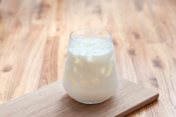 Ice fresh milk in modern galss serve on wooden tray on table in cafe