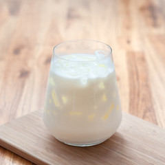 Ice fresh milk in modern galss serve on wooden tray on table in cafe