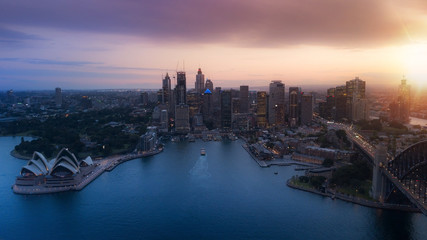 Aerial view of Sydney City during amazing golden sunset with Opera House and Harbour bridge in frame.Small amount of grain due to low light shot.All logotype removed.