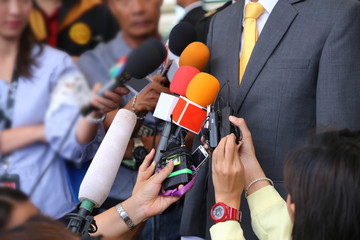 Media interview conept.group of journalists holdig microphone to interviewing VIP