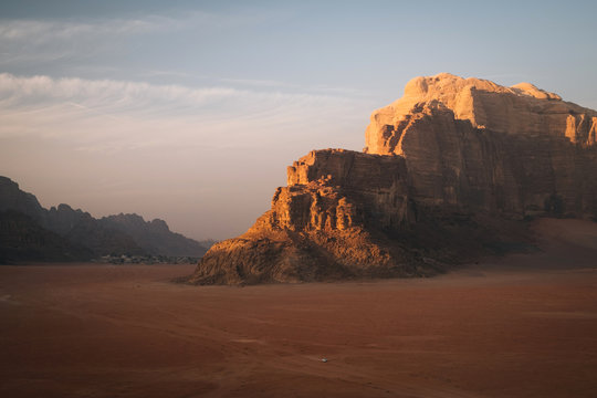 A jeep in the middle of the giant desert of Wadi Rum during sunset