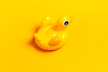 Creative summer beach concept. Inflatable mini yellow chicken or duckling on yellow background, pool float party. Flat lay copy space. Trend Inflatable Children toy for swimming. Layout for design