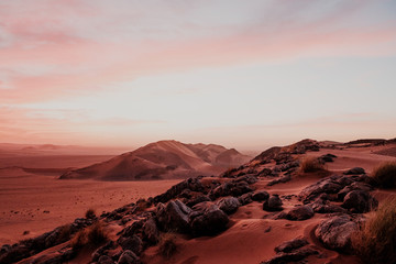 Cloudy sundown sky over hills and rocks in arid desert in evening in Morocco