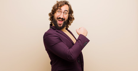 young bearded crazy man feeling happy, positive and successful, motivated when facing a challenge...