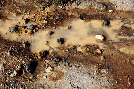 From above swamp with turbid muddy water brown soil and black rocks