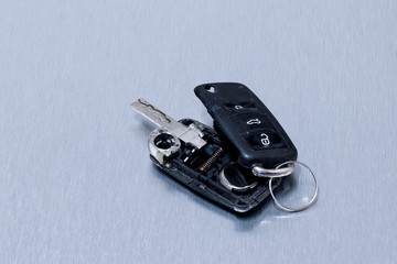Broken or damaged car key fob on aluminium background. Repair of broken or damaged remote key fob of any vehicle car service.- Image