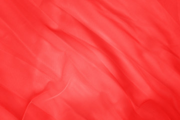 Red cloth texture, close up. Red fabric drape background. Red pink background from draped cloth. Coral color Soft silk cloth or satin texture 