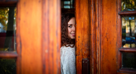 Young woman looking at camera in gap of the doors