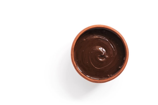 Melted chocolate in a cup on a white background, isolated. Chocolate cream or mousse.View from above.