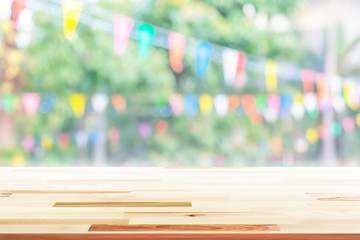 Empty wooden table with party in garden background blurred.