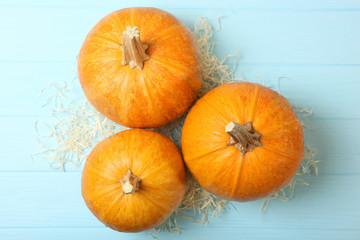 Autumn background with leaves and pumpkins on a colored background top view. Thanksgiving concept.