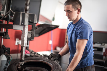 Fototapeta na wymiar Car master mechanic vulcanizer repairing tire on auto vulcanizing machine