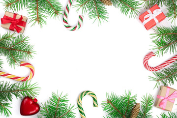 Christmas Frame of Fir tree branch with candy canes and boxes isolated on white background with copy space for your text