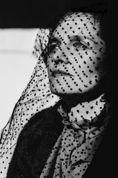 Portrait of a woman with a black dotted veil