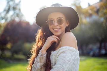 Stylish smiling long haired woman walking in autumn city