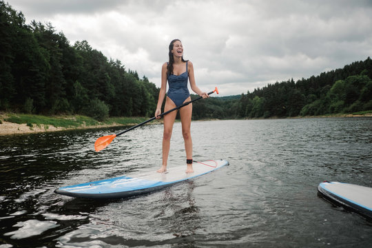 teen girl on paddle board on lake in France