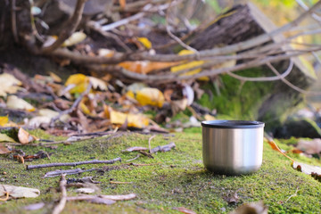 Thermos Vacuum flask in forest and lake. Close up
