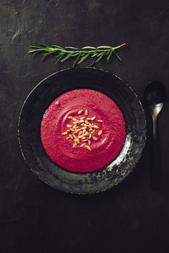 beetroot cream soup with rosemary, grilled sunflower seed on dark background