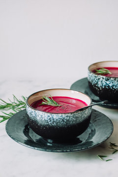 beetroot cream soup with rosemary on white marble table