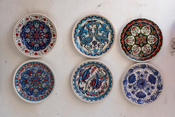Traditional greek ceramic plate on white wall in a street . Kos island, Greece