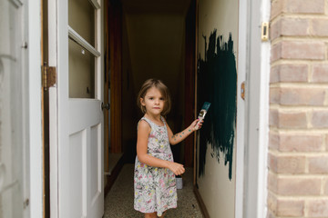 little girl paints hallway