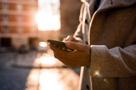 Unrecognizable man using mobile in the street