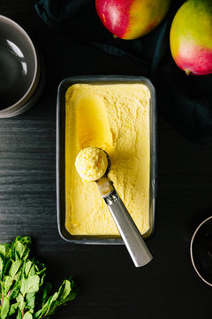 Mango ice cream scooped in metal container