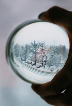 Crop hand holding sphere with winter landscape