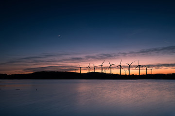 Fototapeta na wymiar Wind turbines motion landscape sunset
