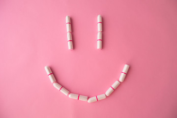 Smiley of tampons on a pink background. Flat lay