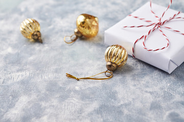 Christmas baubles and Christmas present. Bright wooden background. Copy space. 