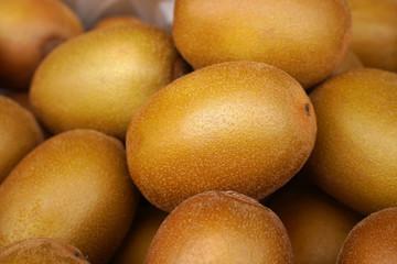 Golden (yellow) organic kiwi as background