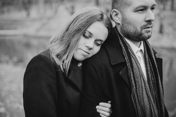 Family story. Lovely couple hug and love outdoor. People dressing in black coat.