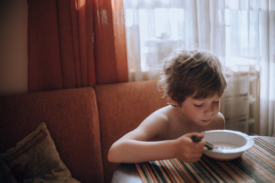 Little boy having breakfast in the kitchen