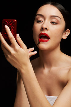 Woman painting lips red