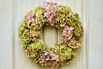 Delightful wreath of hydrangeas on white wooden background close-up