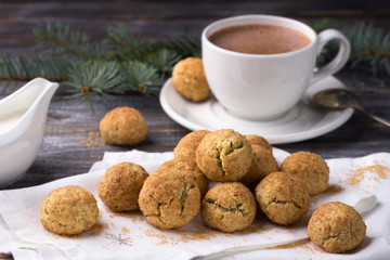 Freshly baked snickerdoodle cookies with cinnamon and nuts, hot chocolate on wooden background