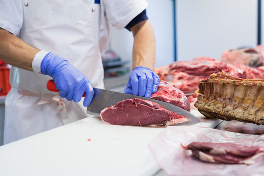Butcher cutting slices of beef